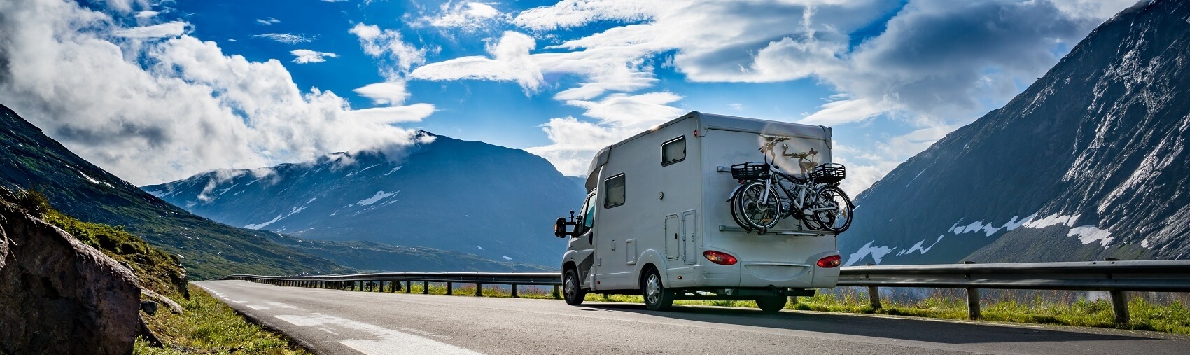 RV driving on the highway with mountains in the background
